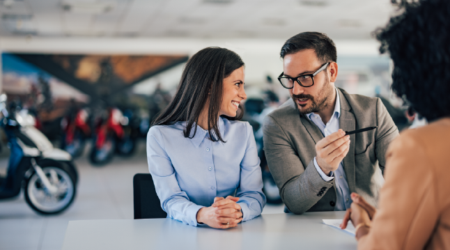 Personas-platicando-en-agencia-de-carros-y-motos
