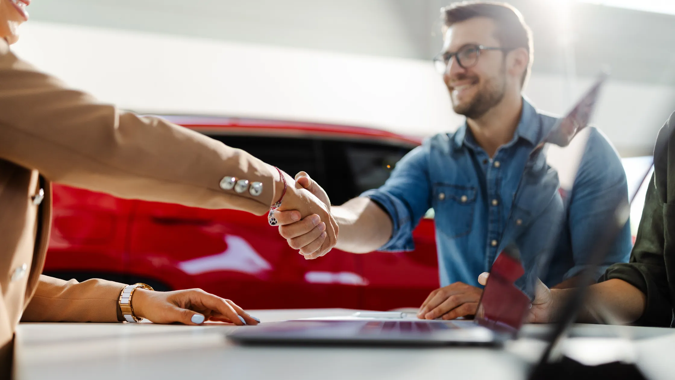 Asesor-estrechando-manos-con-el-cliente-en-la-agencia-solicitando-préstamos-para carros