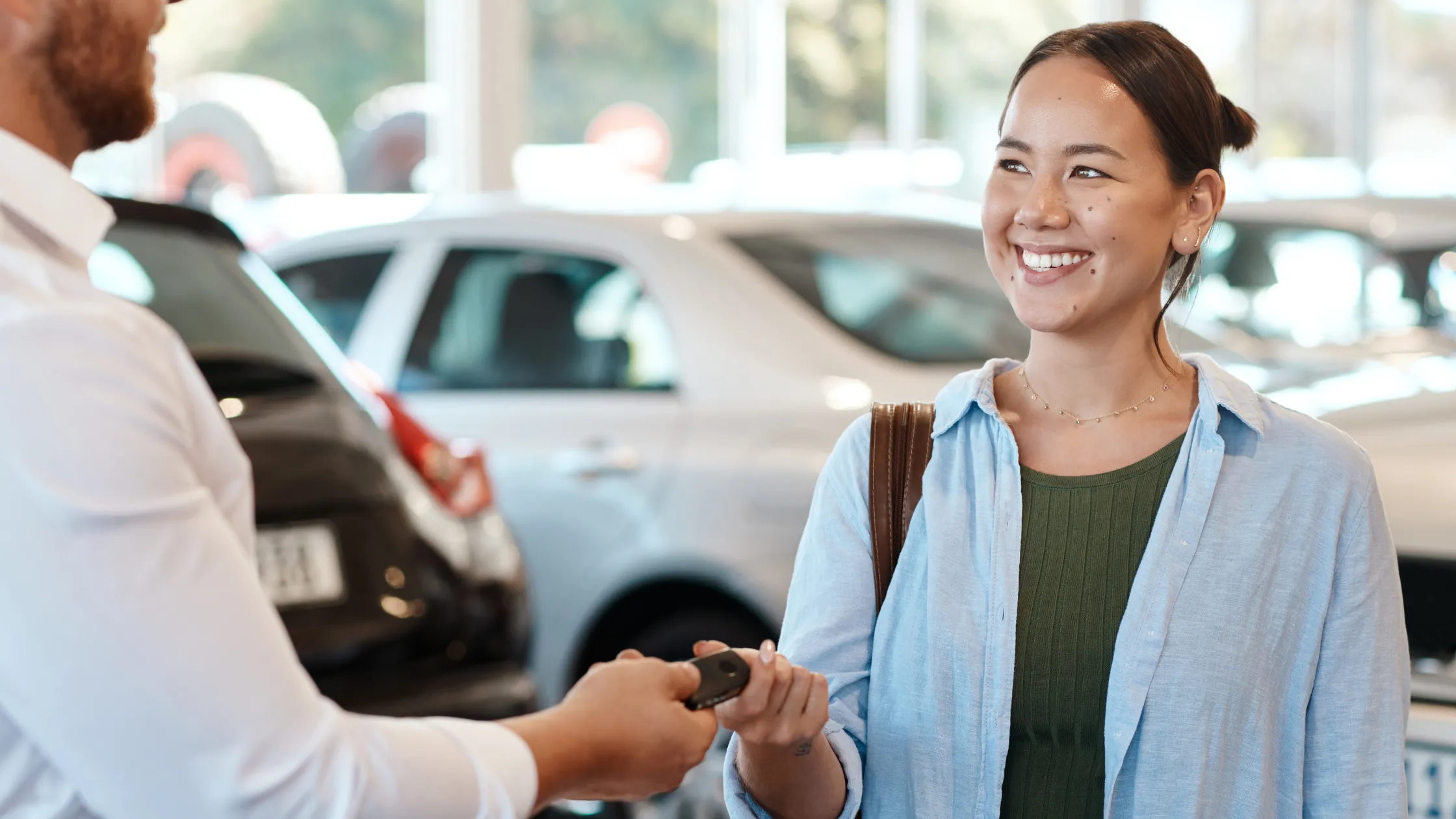 Hombre-entregando-llave-de-auto-a-mujer-sonriente